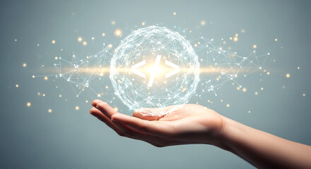 Hand holding a glowing sphere with interconnected lines and a bright light in the center on gray