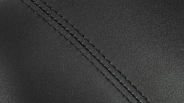 Camera zooms in, revealing rich grain and precise stitching on dark leather