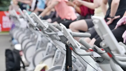 Athletes pedaling on exercise bikes during sports day