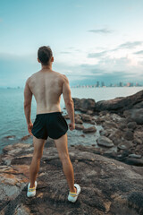Athlete on rock showcases strength and nature challenge, Muscular athletic climber man at mountain peak radiates fitness and rugged success