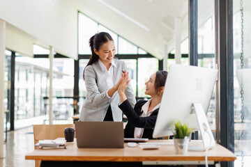 Team of asian women putting hands up for new startup in the office
