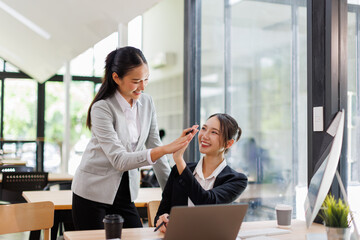 Team of asian women putting hands up for new startup in the office
