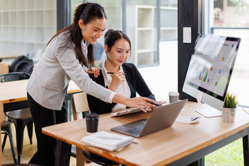 Business asian women Reviewing Documents, Two business meticulously reviewing a stack of documents, highlighting the details and precision in work.	
