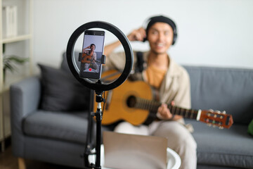 Smartphone On Ring Light Stand Records Blurry Happy Male Musician Playing Guitar