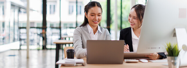 Two busy professional business asian team working together in the office with business documents on laptop computer. 
