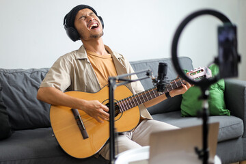 Enthusiastic Young Musician Passionately Singing And Playing Guitar During Online Performance