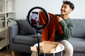Male Content Creator Showing T-Shirt For His Followers Recording Product Review At Home