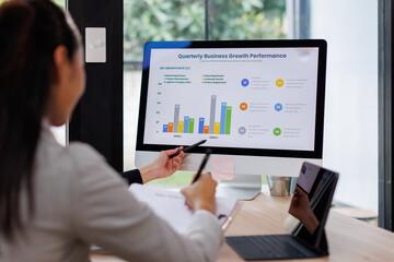 Asian business documents on office table with laptop computer and graph financial with social network diagram and three colleagues discussing data in the background
