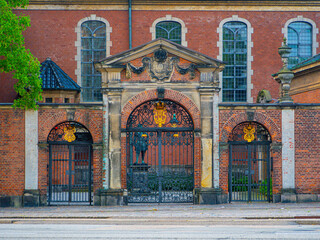Ornate iron gates of Holmen Church in Copenhagen, Denmark, framed by red brick and arched windows—an iconic blend of history, architecture, and European charm.