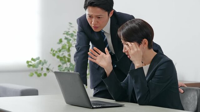 落ち込む女性ビジネスパーソンを慰める男性ビジネスパーソン