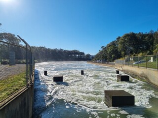 Eraring Power Station Canal water outlet into Myuna Bay New South Wales Australia. A concrete lined canal with fast flowing water and flow control concrete blocks