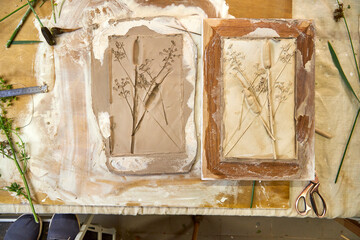Finished botanical plaster relief and clay mold side by side. DIY floral artwork in wooden frame...