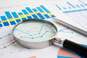 Magnifying glass on spreadsheet and graph paper. Financial data economy, Business.