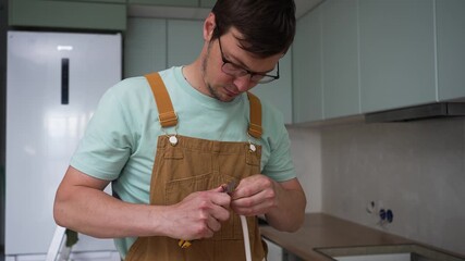 Skilled electrician carefully crimping copper wires using professional crimping tool, ensuring secure electrical connection within modern kitchen renovation project