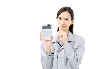 計算機を持ち困る作業服の女性　作業員　事務員　赤字