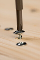 screw for fixing boards and other wood materials, screws with a drill tip twisted into a pine board