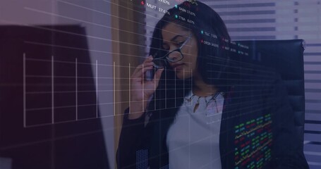 Woman reviewing screen and answering phone call for market update with stock charts updating - Powered by Adobe