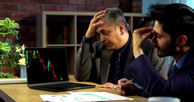 Indian investors worried on market crash, Asian young corporate executives or financial experts looking tense while analyzing stock charts, discussing investment losses and economic downturn - Powered by Adobe