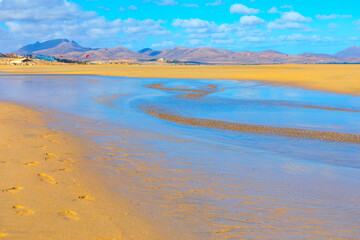 Golden sands and shallow tidal pools stretch across the tranquil beach of Costa Calma,...