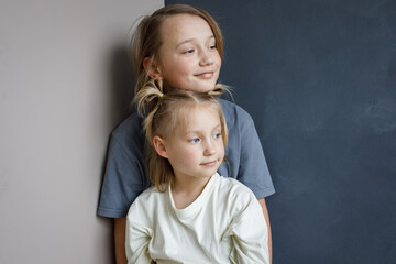 Smiling young sister and brother hugging indoor. Sibling children together portrait