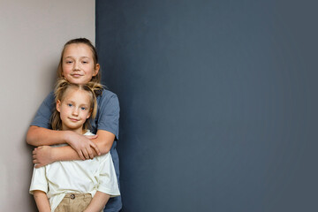 Happy young sister and brother hugging indoor. Sibling children together portrait
