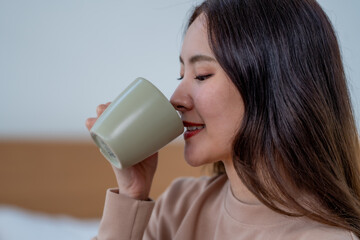 woman enjoying warm beverage from green mug, exuding relaxation and comfort. cozy atmosphere...