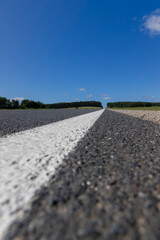 paved road during the day in sunny weather , paved road for vehicles with white road markings
