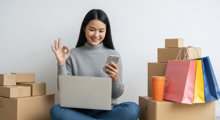 Young woman shopping online with laptop, smartphone, cardboard box, colorful bag, and coffee cup, feeling happy