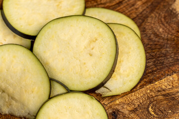 purple eggplant sliced across with small seeds inside, ripe purple delicious eggplant sliced across the fruit on the kitchen table