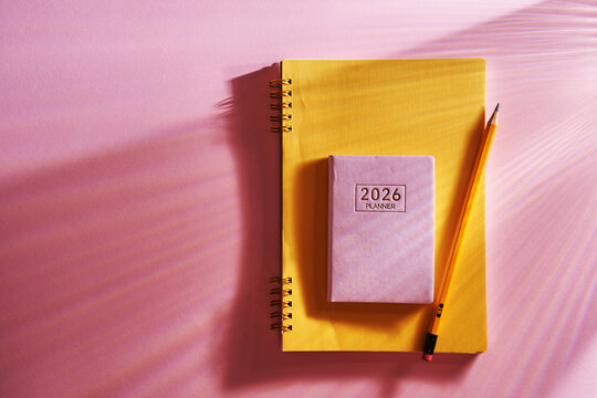 2026 planner and pencil  against pink background.