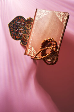 top view of koran stand with prayer beaads and holy koran.