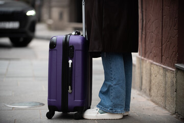 Close up of traveler with suitcase on city sidewalk