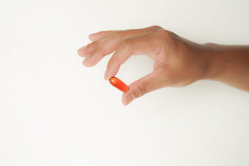 Male hand holding soft gels, Fish oil capsules, omega 3, omega 9, vitamin D, vitamin E, supplements