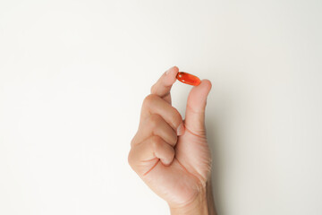 Male hand holding soft gels, Fish oil capsules, omega 3, omega 9, vitamin D, vitamin E, supplements