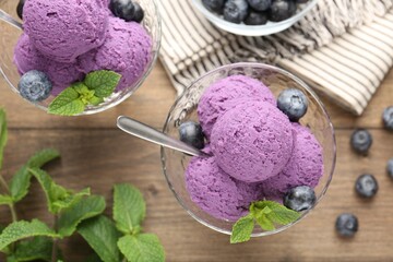 Tasty sorbet with blueberries and mint in dessert bowls on wooden table, flat lay