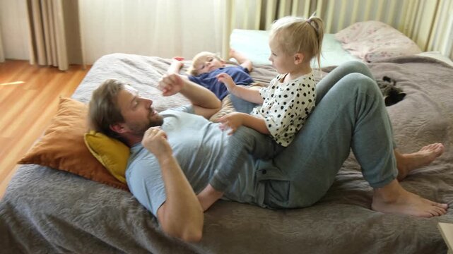 Happy Father Playing with Children. Litle Kids Smiling, Laughing, Jumping at Daddy. Man Showing Affection. Candid Real Emotion. Beard Dad and Little Kid Girl and Boy. Authentic Family Lifestyle
