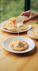 A person is pouring a white liquid over a plate of food