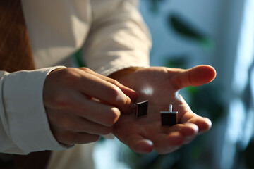 Man with cufflinks getting ready indoors, closeup