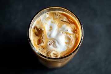 A glass of coffee with foam on top