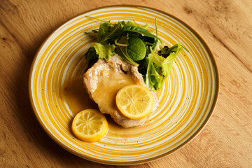 Lemon pork chop with fresh salad on ceramic plate