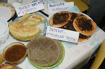 Buffet table set with a variety of Ethiopian breads, including Injera and dabo, and Russian...