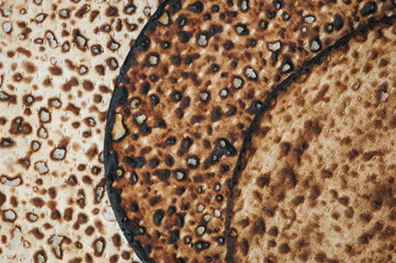 Abstract closeup image of sheets of round shmura matzah or matzo, unleavened bread eaten by Jews during the holiday of Passover.