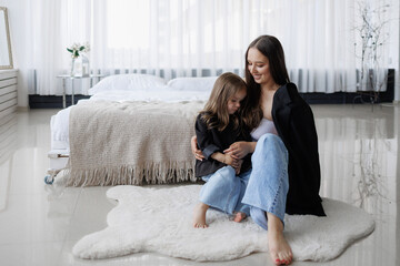 Mother and daughter enjoying quiet time together in a modern bedroom