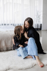 Mother and daughter share a loving moment in a cozy modern living space