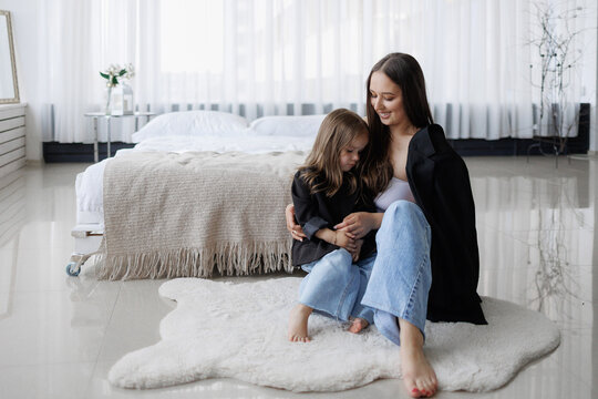 Mother and daughter enjoying quiet time together in a modern bedroom - Powered by Adobe