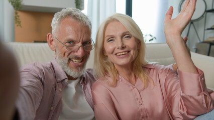 Cheerful Caucasian old senior elderly couple family talking mobile phone gadget man male woman...