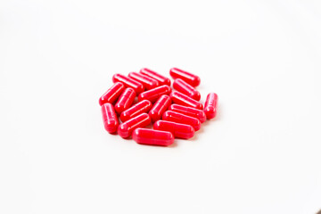 Red astaxanthin supplement capsules on a white background.