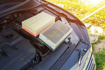 New clean and old dirty air filter in the engine compartment of the car. Technical maintenance of...