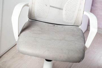 Dirty gray upholstery fabric with stains on computer chair before dry cleaning, close-up