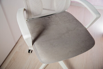 Dirty gray upholstery fabric with stains on computer chair before dry cleaning, close-up